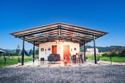 a house with awning and a little girl in front of it at Cabaña Pantano de Vargas con fogata y parrilla privado in Tibasosa