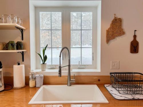 a kitchen counter with a sink and a window at White Mountain Dream Cabin in Fryeburg
