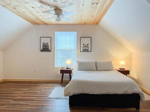 a bedroom with a bed and a ceiling fan at White Mountain Dream Cabin in Fryeburg