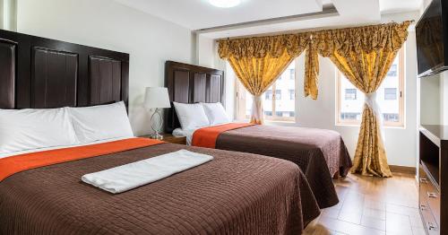 a hotel room with two beds and a window at Hotel Plaza Tapatia in Guadalajara