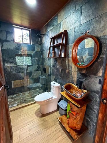 a bathroom with a toilet and a sink and a mirror at Cabaña Lancero in San Pedro