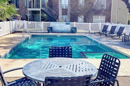 a table and chairs next to a swimming pool at Spacious Poolside Oasis - Easy Access and Garage in Corpus Christi