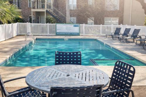 a table and chairs next to a swimming pool at Pool View Escape - Near Shops and Dining in Corpus Christi