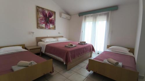 a room with two beds and a window at Apartmani Nina in Starigrad