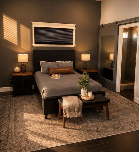 a bedroom with a bed and a table and two lamps at Desert Disconnect Outdoor Cinema and Pool in Mesa
