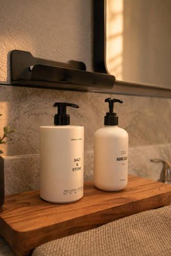 two bottles of soap on a wooden shelf in a bathroom at Desert Disconnect Outdoor Cinema and Pool in Mesa