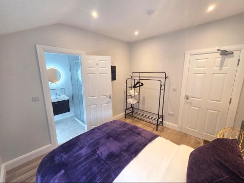 a bedroom with a bed and a room with a sink at Newly Refurbished Townhouse in Derry Londonderry
