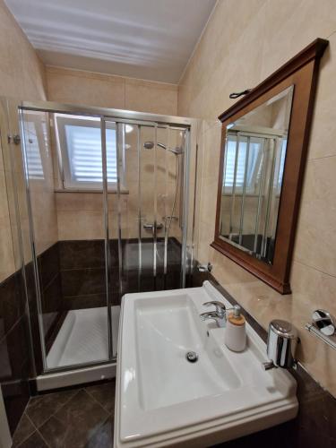 a bathroom with a shower and a sink and a mirror at Blue Diamond Rooms in Zaton