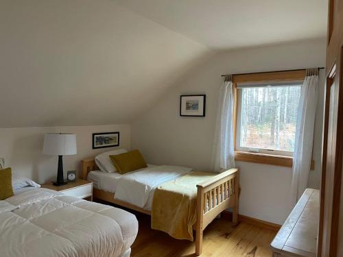 a bedroom with two beds and a window at Authentic VT Chalet, Hot tub, Fire pit, Mt Snow in Dover
