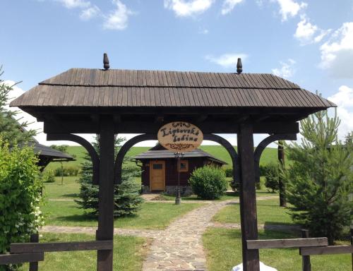 a wooden gazebo with a sign on it at Tatralandia-Liptov Chatky in Liptovský Mikuláš