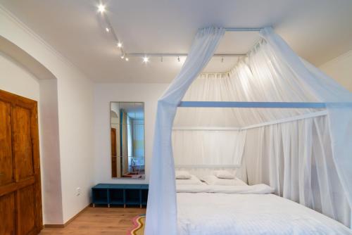 a bedroom with a white bed with a canopy at WanaBark Hotel - The Ultimate Dogs-friendly Spot in Bratislava in Bratislava
