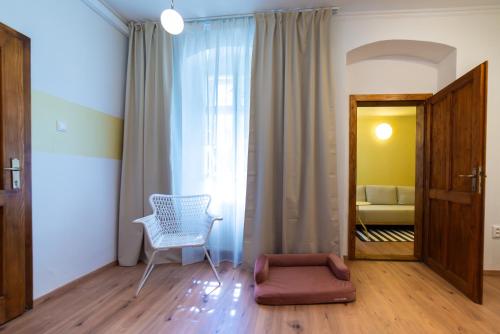 a living room with a chair and a window at WanaBark Hotel - The Ultimate Dogs-friendly Spot in Bratislava in Bratislava