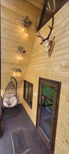 Ein Raum mit einer Holzwand, einer Tür und einem Elchschädel in der Unterkunft Cabanuta Lunca in Lunca