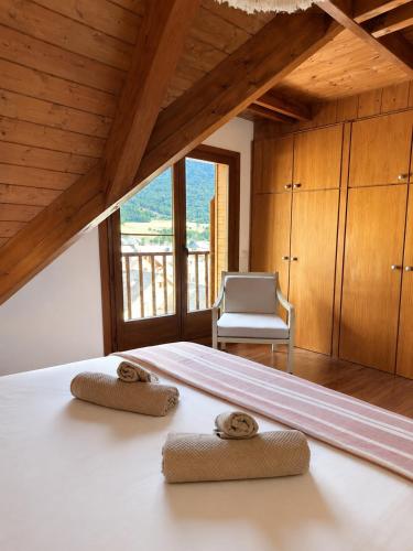ein Schlafzimmer mit einem Bett, auf dem zwei Handtücher liegen in der Unterkunft Montlude in Bossost
