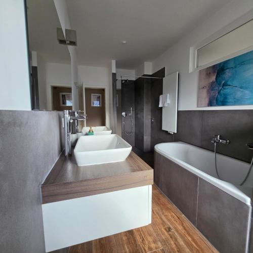 a bathroom with a sink and a tub and a bath tub at Villa Eckhart in Göhren