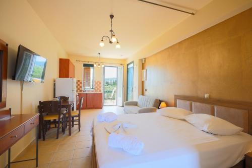 a bedroom with a bed and a living room and a kitchen at Remenata in Lixouri