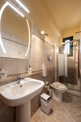 a bathroom with a sink and a toilet and a mirror at Remenata in Lixouri