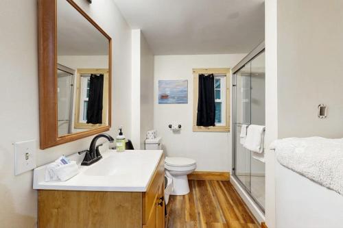 a bathroom with a sink and a toilet and a mirror at 2-story apartment steps from the harbor & downtown in Boothbay Harbor