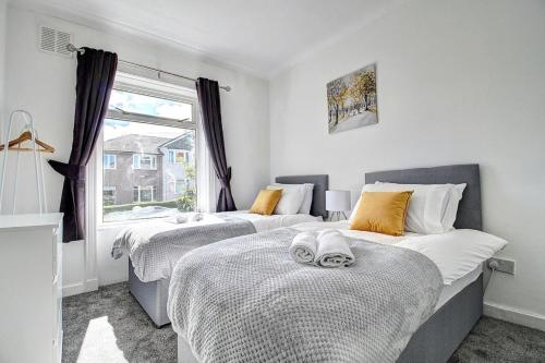 a bedroom with two beds and a window at Kingspark Apartment Apartment in Glasgow