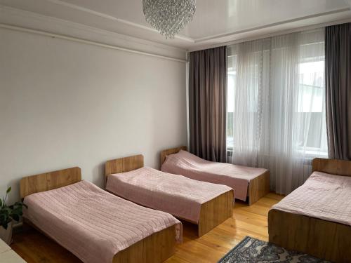 a room with three beds and a window at Guest Home in Jalal-Abad