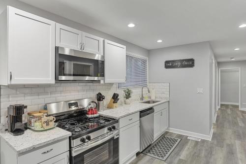 a kitchen with white cabinets and a stove top oven at Cozy 4BR 2BA Worth Home in Worth