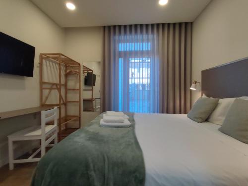 a bedroom with a bed with a desk and a ladder at Barcelos Habadia da Loja in Lijó