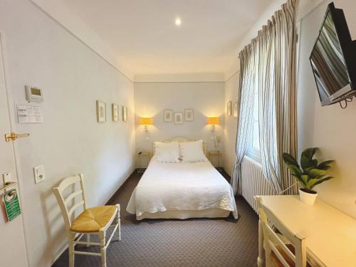 a hotel room with a bed and a chair at Le Relais Notre Dame in Quinson