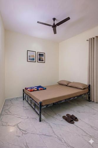 a bed in a room with a ceiling fan at Forum Stay in Mysore