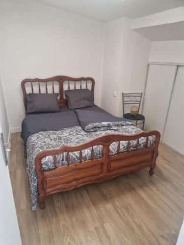 a bedroom with a wooden bed in a room at Appartement 2 Ch la Romagne in La Romagne
