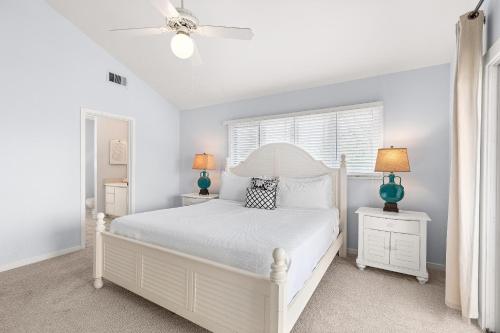 a white bedroom with a white bed and two lamps at Madelyn's Oceanview in Tybee Island