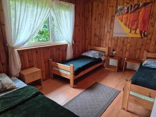a bedroom with two twin beds and a window at Dom pod lipą in Łeba