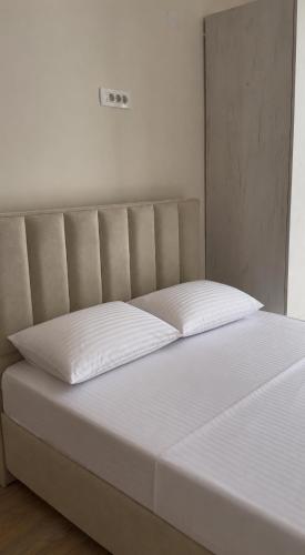 a bed with two white pillows on top of it at Villa Brodetto, Sveti Stefan in Pržno