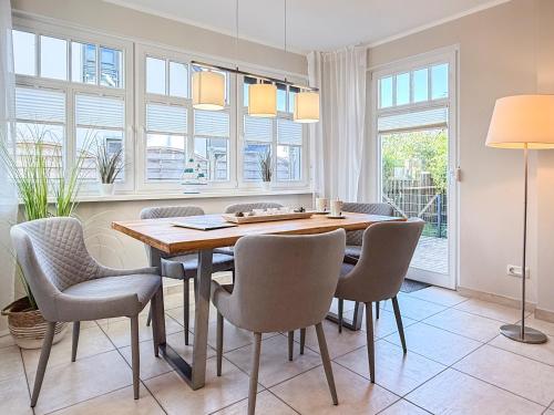 a dining room with a table and chairs and windows at Kinnekulle 1 in Groß Kirr