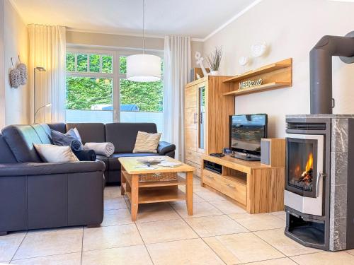 a living room with a couch and a fireplace at Kinnekulle 1 in Groß Kirr