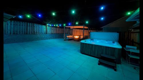 a patio at night with a hot tub and lights at Cozy Seaside Bungalow, Brand New Hot Tub, Fast WiFi & W&D - Walk to the Beach in Seaside