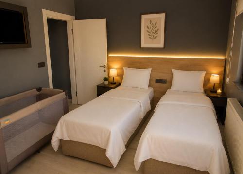 a hotel room with two beds and a television at Eylül Homes in Trabzon