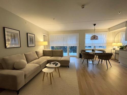 a living room with a couch and a table at Modern apartment with a private garage in Lørenskog Oslo in Lorenskog