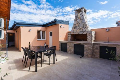 a patio with a table and chairs and a fireplace at Villa Bali Oasis Grand Wellness in Stolac