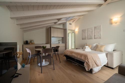 a bedroom with a bed and a table and chairs at Flowers Liberty Suites in Brescia