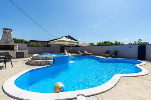 a large swimming pool in a backyard at Villa Bali Oasis Grand Wellness in Stolac