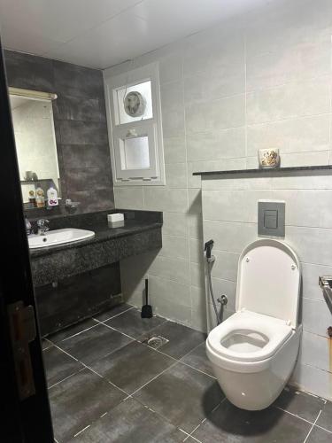 a bathroom with a toilet and a sink at شقة كبيرة مؤثثة بالكامل in Salalah