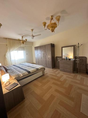 a bedroom with a bed and a dresser and a mirror at شقة كبيرة مؤثثة بالكامل in Salalah