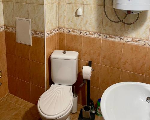 a bathroom with a white toilet and a sink at Europe Holiday Apartments First Sea Line Coast in Pomorie