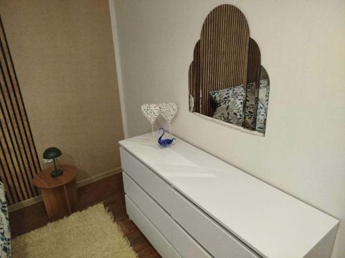 a white dresser in a bedroom with a mirror at Apartamenty nad Brdą in Zapędowo