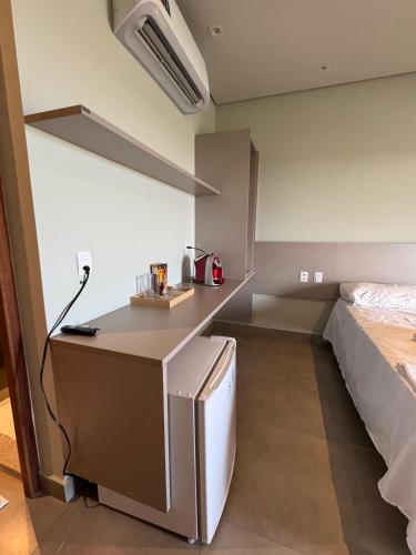 a kitchen with a refrigerator and a bed in a room at Apartamento 313 Bobz Concept in Cajueiro