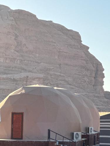 a large dome with a mountain in the background at Rehana rum luxury camp in Wadi Rum