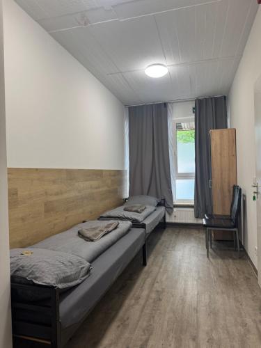 two beds in a room with a window at Hansa Pension 2 Hamburg - Ruhige Zimmer mit Gemeinschaftsküche in Hamburg