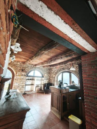 a kitchen with a brick wall and a brick floor at Country Cottage by LePigne World in Ameno