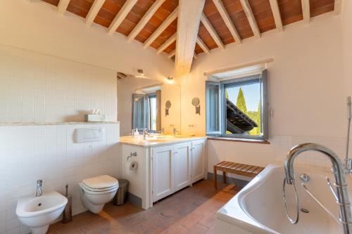 a bathroom with a tub and a toilet and a sink at Private Tuscan Villa with Infinity Pool & Views in Vagliagli
