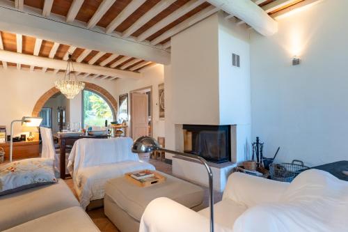 a living room with white furniture and a fireplace at Private Tuscan Villa with Infinity Pool & Views in Vagliagli